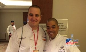 Chef Aaron wearing a white uniform and posing with another chef