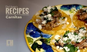 A tray of carnita street tacos on a colorful plate